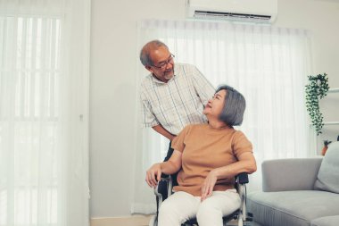 A contented senior couple and their in-home nurse. Elderly female in wheelchair with her young caregiver.