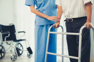 Physiotherapist assists her contented senior patient on folding walker. Recuperation for elderly, seniors care, nursing home.