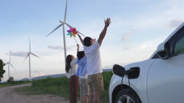 Концепція Прогресивної Щасливої Сім Насолоджується Вітроелектромобілем Вітроелектростанції Електричний Транспортний Засіб — стокове відео