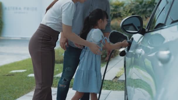 電気自動車用充電ステーションを備えた進歩的な家族の概念は 健康できれいな環境を奨励しています 持続可能でクリーンなエネルギー技術を搭載した電気自動車 — ストック動画