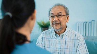 A young female doctor inquires about personal information of a contented senior at home. Medical care for the elderly, elderly illness, and nursing homes, home care.