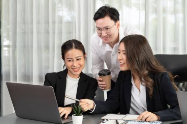 Harmony in office concept as business people analyzing dashboard paper together in workplace. Young colleagues give ideas at manager desk for discussion or strategy planning about project.