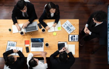 Top view manager or office worker give presentation in harmony conference room to business colleague, BI data dashboard on screen and pile of financial analyzed data reports on meeting table.