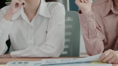 Ofis çalışma alanında birlikte çalışan iki genç hevesli iş kadını. Genç meslektaşlar tartışırken ve dizüstü bilgisayar kullanırken. Modern ofis çalışanları masada birlikte oturuyorlar..