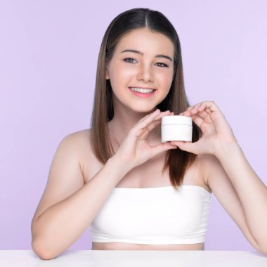 Young charming girl with natural beauty, perfect smooth skin hold lotion, cream, moisturizer jar. Beautiful girl show skincare product smiling on isolated background.