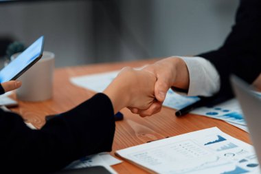 Focus handshake by businessman in formal wear in meeting room after successful agreement or deal. Colleagues shake hands to each other after getting promotion as concept of harmony and unity concept.