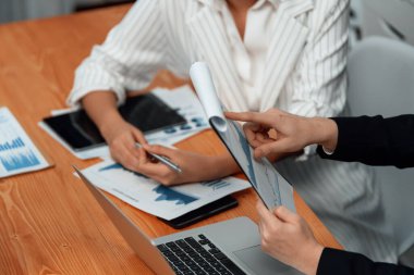 Harmony in office concept as business people analyzing dashboard paper together in workplace. Young colleagues give ideas at manager desk for discussion or strategy planning about project.