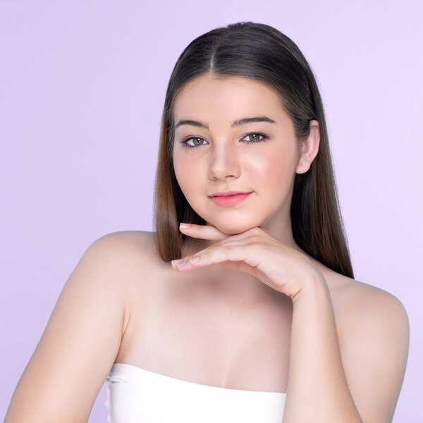 Портрет юной брюнетки с длинными волосами и безупречной кожей с жестом руки для красоты и косметической концепции. очаровательная красивая молодая девушка позирует руки для кожи или косметической рекламы.