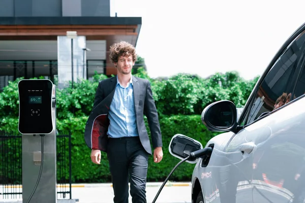 Progressive Businessman Wearing Black Suit Electric Car Recharging Public Parking — стоковое фото