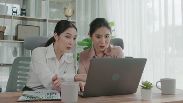 2人の若い熱心なビジネスマンがオフィスワークスペースで一緒に働いています 若い同僚が一緒にノートパソコンを議論し 使用しています デスクに座っている現代のオフィスワーカー — ストック動画