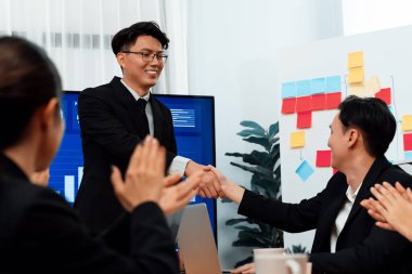 Businesspeople shake hand after successful agreement or meeting. Office worker colleague handshake with business team leader manager for strong teamwork in office to promote harmony and unity concept.