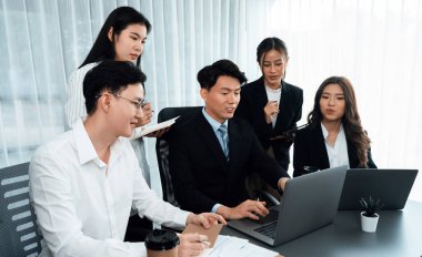 Harmony in office concept as business people analyzing dashboard paper together in workplace. Young colleagues give ideas at manager desk for discussion or strategy planning about project.