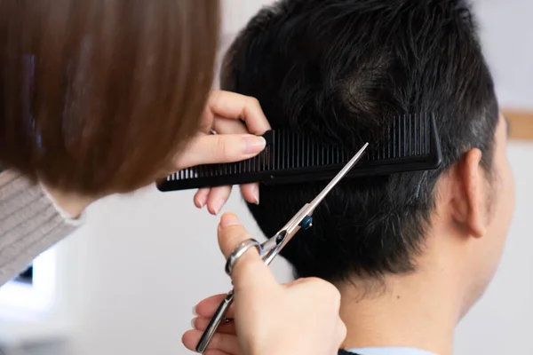 在合格的理发店里 亚洲女性理发师为男性顾客理发 男性理发师为男性顾客理发 美发沙龙概念中的剪子和梳子式发型 — 图库照片