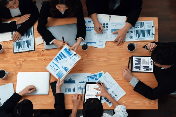 Top-view business team of financial data analysis meeting with business intelligence, report paper and dashboard on laptop for marketing strategy. Business people working together in office of harmony