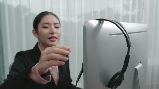 亚洲客户支持操作员戴着耳机和话筒 带着笔记本电脑在她的办公桌前工作 热心的女员工提供客户服务 支持呼叫中心代理帮助客户 — 图库视频影像