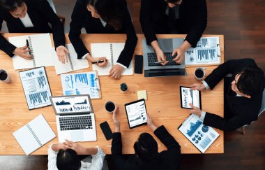 Top-view business team of financial data analysis meeting with business intelligence, report paper and dashboard on laptop for marketing strategy. Business people working together in office of harmony