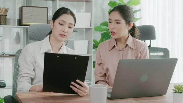 2人の若い熱心なビジネスマンがオフィスワークスペースで一緒に働いています 若い同僚が一緒にノートパソコンを議論し 使用しています デスクに座っている現代のオフィスワーカー — ストック写真