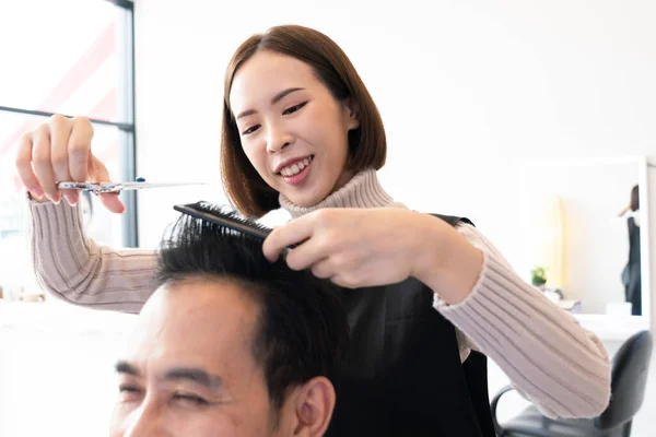 在合格的理发店里 亚洲女性理发师为男性顾客理发 男性理发师为男性顾客理发 美发沙龙概念中的剪子和梳子式发型 — 图库照片