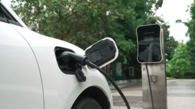 Elektrikli araba parkı ve şarj istasyonunun yanında şarj edilen enerji konseptinin sürdürülebilirliği. Çevresel koruma için yenilenebilir enerji tarafından kullanılan elektrikli araç.