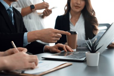 Harmony in office concept as business people analyzing dashboard paper together in workplace. Young colleagues give ideas at manager desk for discussion or strategy planning about project.