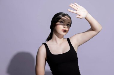 Young charming caucasian teenager girl with clean and fresh skin posing pointing fingers on empty background for beauty advertising. Cute smiling expression. Present beauty skincare cosmetic product.