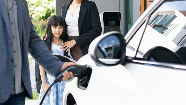 Progressive Young Parents Daughter Electric Vehicle Home Charging Station Green — Stok fotoğraf
