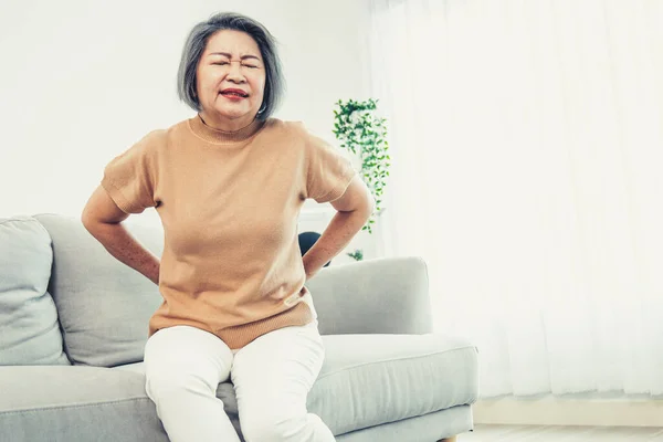 Agonizing Senior Woman Experiencing Back Pain While Sitting Her Sofa — Stock fotografie