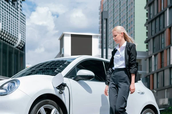 Progressive Businesswoman Wearing Suit Electric Car Recharging Public Parking Car — Stok fotoğraf