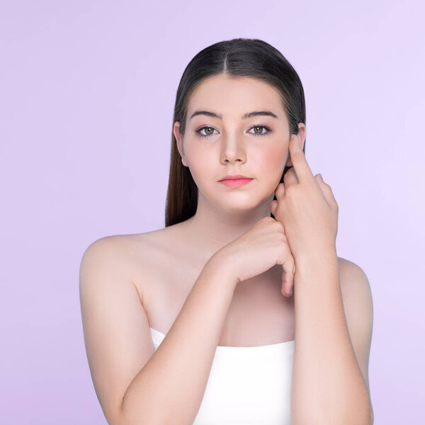 Портрет юной брюнетки с длинными волосами и безупречной кожей с жестом руки для красоты и косметической концепции. очаровательная красивая молодая девушка позирует руки для кожи или косметической рекламы.