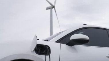 Çevreyi korumak için rüzgar türbininden yeşil ve yenilenebilir enerjiyle çalışan şarj istasyonunda şarj edilen gelişmiş gelecek enerji altyapısı konsepti.