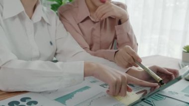 Ofis çalışma alanında birlikte çalışan iki genç hevesli iş kadını. Genç meslektaşlar tartışırken ve dizüstü bilgisayar kullanırken. Modern ofis çalışanları masada birlikte oturuyorlar..