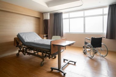 Rahatlatıcı modern hasta yatağı ile donatılmış steril tedavi odası. Hastanenin yatak odası ya da koğuşunun fotoğrafı..