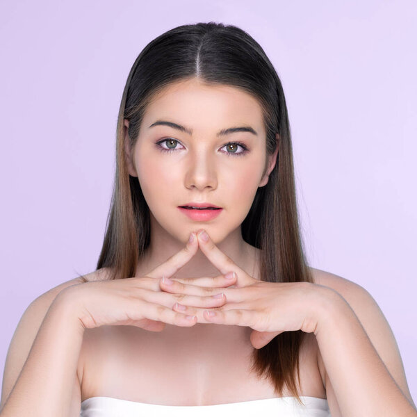 Портрет юной брюнетки с длинными волосами и безупречной кожей с жестом руки для красоты и косметической концепции. очаровательная красивая молодая девушка позирует руки для кожи или косметической рекламы.