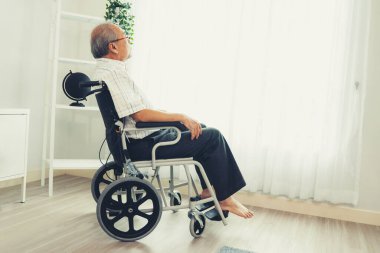Portrait of a contented elderly man in sitting on a wheelchair at home. Senior person in nursing house service .