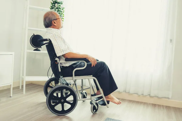 stock image Portrait of a contented elderly man in sitting on a wheelchair at home. Senior person in nursing house service .