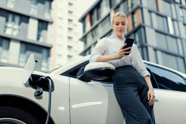 Closeup Progressive Businesswoman Talking Smartphone Leaning Electric Car Charging Station — Foto Stock