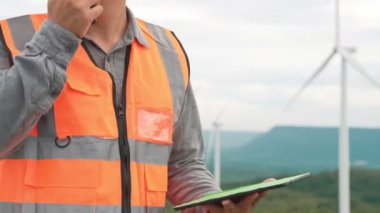 Kırsal kesimdeki bir tepenin tepesinde ya da dağda rüzgar çiftliğinde çalışan bir mühendis. Yenilenebilir ve sürdürülebilir enerjinin gelecekteki üretimi için yenilikçi bir ideal. Rüzgar türbininden enerji üretimi.