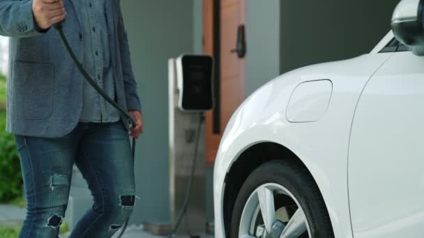 電気自動車用充電ステーションを備えた進歩的な家族の概念は 健康できれいな環境を奨励しています 持続可能でクリーンなエネルギー技術を搭載した電気自動車 — ストック動画