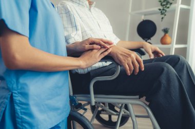 Caring nurse and a contented senior man in a wheel chair at home, nursing house. Medical for elderly senior, home care for pensioners.