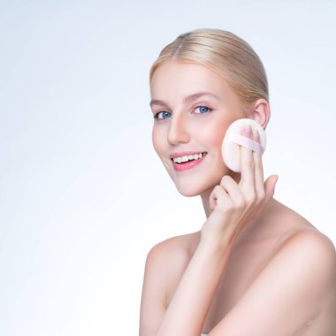 Personable beautiful natural soft makeup woman using powder puff for facial makeup concept. Cushion foundation applying on young girl face in isolated background.