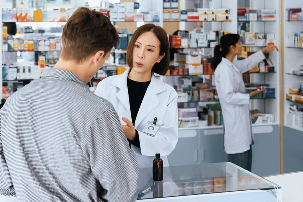 약사는 자격증 의약품의 특성을 약국의 고객에게 조언하거나 설명하거나 약국의 약사가 — 스톡 사진