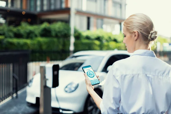 Suit Clad Progressive Businesswoman Look Cars Battery Status Her Phone — Stockfoto