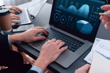 Business team analyze business analytic or business intelligence dashboard on laptop screen show graph and chart with statistic in harmony office. Analyst team meeting researching, planning strategy.