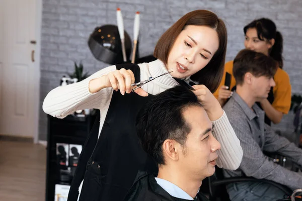 Азійська Жінка Перукарка Робить Зачіску Двох Чоловіків Клієнтів Чоловічою Зачіскою — стокове фото