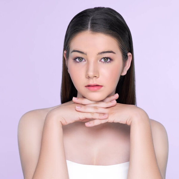 Портрет юной брюнетки с длинными волосами и безупречной кожей с жестом руки для красоты и косметической концепции. очаровательная красивая молодая девушка позирует руки для кожи или косметической рекламы.