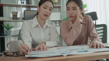 Ofis çalışma alanında birlikte çalışan iki genç hevesli iş kadını. Genç meslektaşlar tartışırken ve dizüstü bilgisayar kullanırken. Modern ofis çalışanları masada birlikte oturuyorlar..