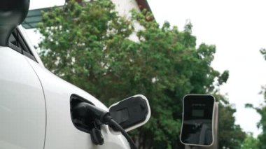 Elektrikli araba parkı ve şarj istasyonunun yanında şarj edilen enerji konseptinin sürdürülebilirliği. Çevresel koruma için yenilenebilir enerji tarafından kullanılan elektrikli araç.