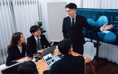 Confidence and asian businessman give presentation on financial analyzed by business intelligence in dashboard report to other people in board room meeting to promote harmony in workplace.