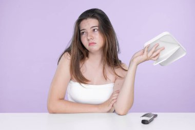 Young charming teenager girl worry about her face pimples on mirror for skincare and acne problem concept. Stress young girl squeezing pimples and pointing fingers on acne on her face.