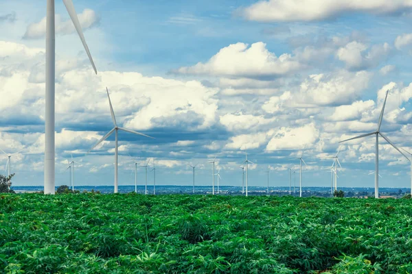 グリーンフィールドや丘の上に風力タービンファームによって現代の生活様式を電力する再生可能エネルギー源として風力を利用する進歩的な方法 風車発電機はCo2排出のない電気を発生させます — ストック写真
